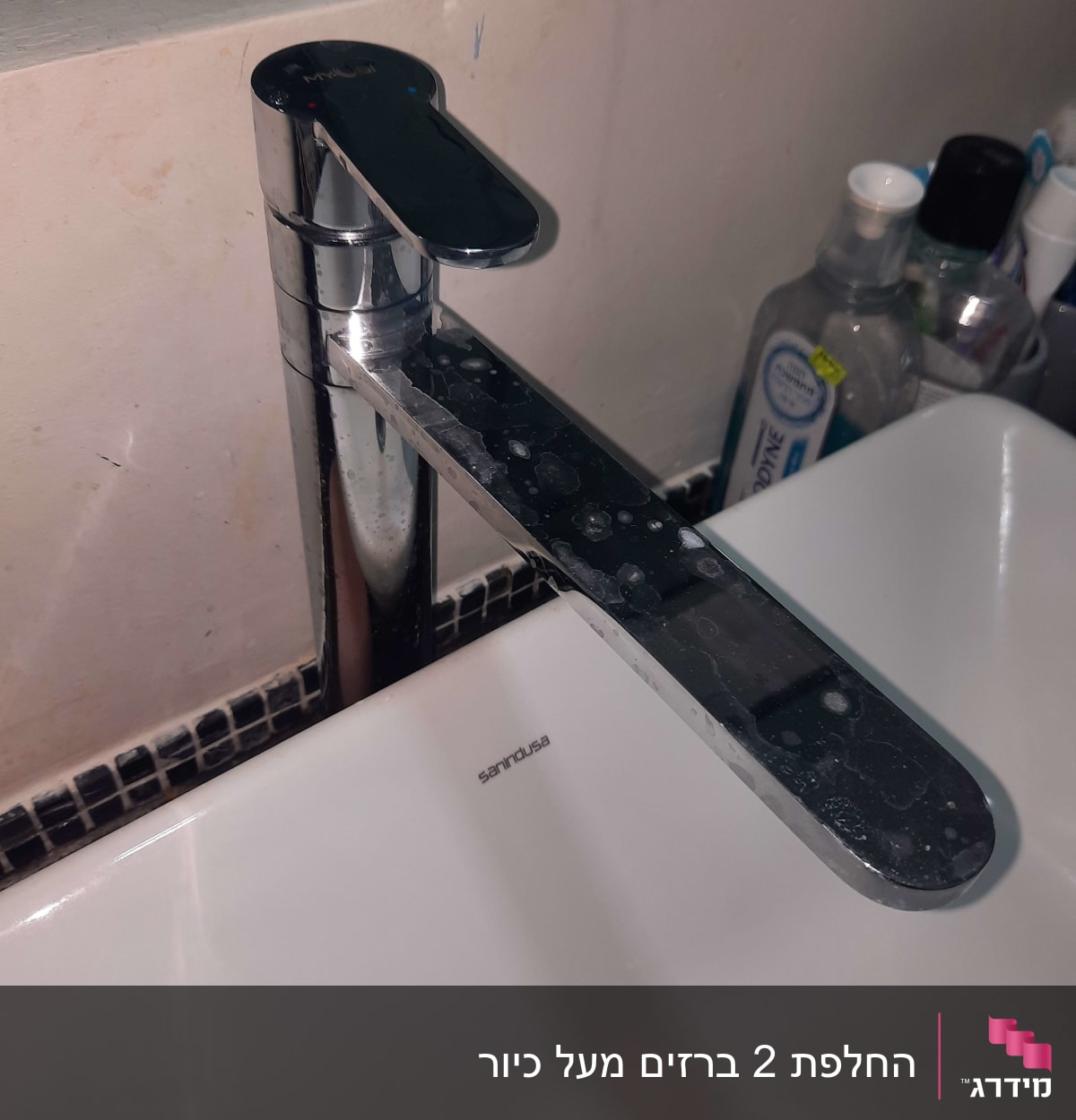 ברז כרום עם כתמי מים על כיור לבן
